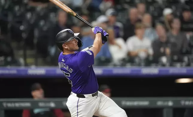 Colorado Rockies' Hunter Goodman follows the flight of his solo home run off Arizona Diamondbacks relief pitcher Blake Walston in the seventh inning of a baseball game Tuesday, Sept. 17, 2024, in Denver. (AP Photo/David Zalubowski)