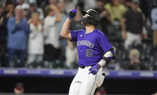 Colorado Rockies' Hunter Goodman gestures as he crosses home plate after hitting a solo home run off Arizona Diamondbacks relief pitcher Blake Walston in the seventh inning of a baseball game Tuesday, Sept. 17, 2024, in Denver. (AP Photo/David Zalubowski)