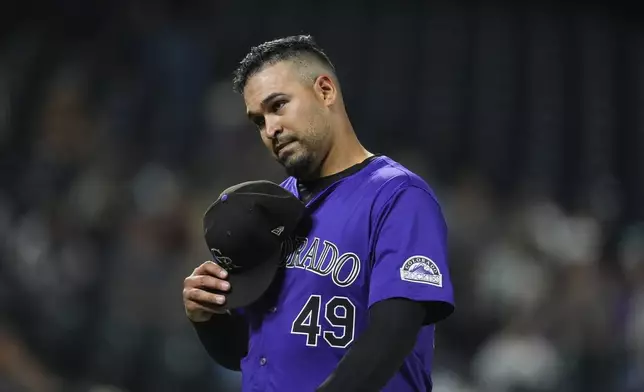 Colorado Rockies starting pitcher Antonio Senzatela takes of his cap as he heads to the dugout after bing pulled from the mound in the fourth inning of a baseball game against the Arizona Diamondbacks, Monday, Sept. 16, 2024, in Denver. (AP Photo/David Zalubowski)