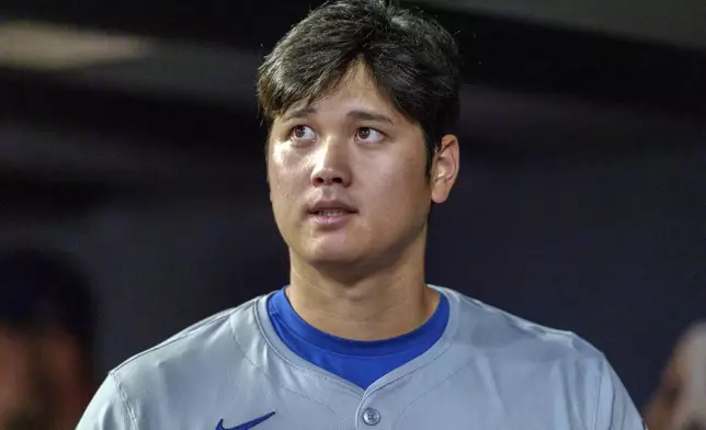 Los Angeles Dodgers two-way player Shohei Ohtani checks the scoreboard from the dugout in the third inning of a baseball game against the Atlanta Braves, Monday, Sept. 16, 2024, in Atlanta. (AP Photo/Jason Allen)