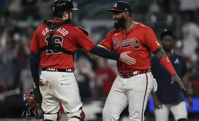 Atlanta Braves designated hitter Marcell Ozuna, right, celebrates a win with catcher Travis d'Arnaud after a baseball game against the Los Angeles Dodgers, Friday, Sept. 13, 2024, in Atlanta. (AP Photo/Mike Stewart)