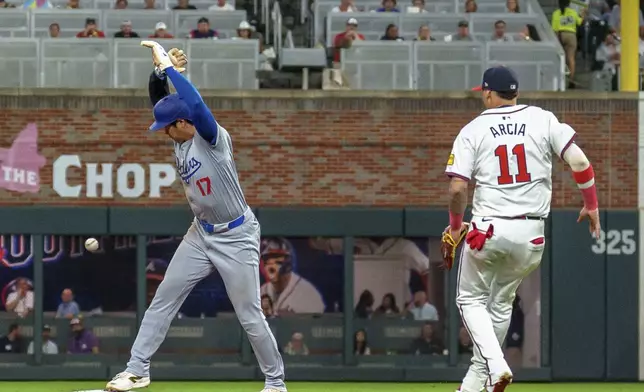 Los Angeles Dodgers' Shohei Ohtani, left, tags second base before Atlanta Braves shortstop Orlando Arcia, right, can get the ball in the seventh inning of a baseball game, Monday, Sept. 16, 2024, in Atlanta. (AP Photo/Jason Allen)