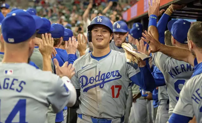 Los Angeles Dodgers' Shohei Ohtani (17) celebrates in the dugout after Freddie Freeman hit a three-run home run in the seventh inning of a baseball game against the Atlanta Braves, Monday, Sept. 16, 2024, in Atlanta. (AP Photo/Jason Allen)