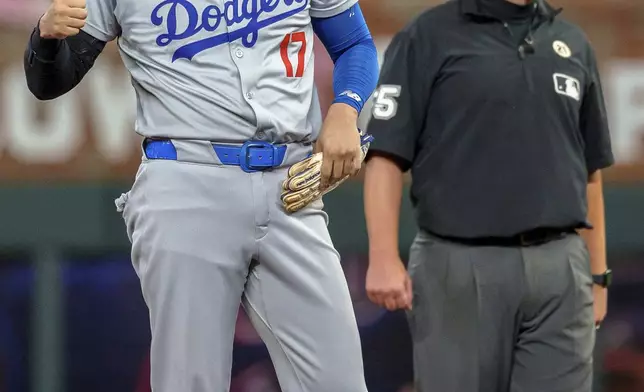 Los Angeles Dodgers' Shohei Ohtani gives a thumbs up to the dugout after hitting a double in the fifth inning of a baseball game against he Atlanta Braves, Sunday, Sept. 15, 2024, in Atlanta. (AP Photo/Jason Allen)