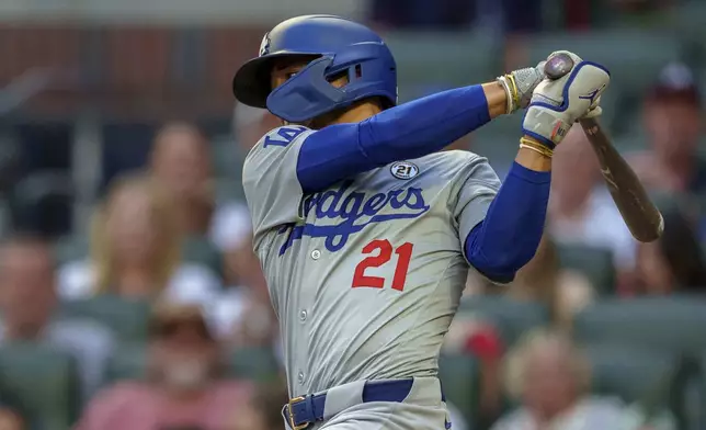 Los Angeles Dodgers' Mookie Betts swings at the pitch in the first inning of a baseball game wearing 21 in commemoration of Roberto Clemente against the the Atlanta Braves, Sunday, Sept. 15, 2024, in Atlanta. (AP Photo/Jason Allen)