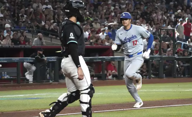 Los Angeles Dodgers' Shohei Ohtani (17) runs to score against the Arizona Diamondbacks on a sacrifice fly by Freddie Freeman in the seventh inning during a baseball game, Monday, Sept. 2, 2024, in Phoenix. (AP Photo/Rick Scuteri)