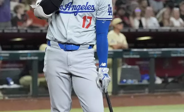 Los Angeles Dodgers designated hitter Shohei Ohtani, of Japan, pauses after being called out on strikes against the Arizona Diamondbacks during the eighth inning of a baseball game Saturday, Aug. 31, 2024, in Phoenix. (AP Photo/Ross D. Franklin)