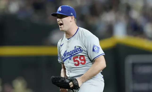 Los Angeles Dodgers relief pitcher Evan Phillips celebrates after the final out of a baseball game against the Arizona Diamondbacks, Saturday, Aug. 31, 2024, in Phoenix. (AP Photo/Ross D. Franklin)