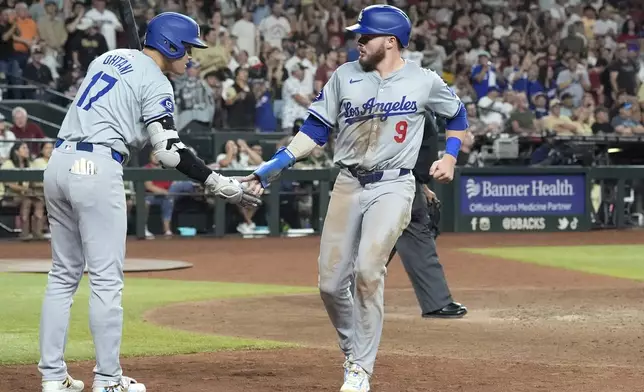 Los Angeles Dodgers' Gavin Lux (9) celebrates his run scored against against the Arizona Diamondbacks with Dodgers' Shohei Ohtani (17), of Japan, during the ninth inning of a baseball game Saturday, Aug. 31, 2024, in Phoenix. (AP Photo/Ross D. Franklin)