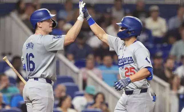 Los Angeles Dodgers' Tommy Edman (25) celebrates his two-run home run with Will Smith (16) during the fourth inning of a baseball game against the Miami Marlins, Wednesday, Sept. 18, 2024, in Miami. (AP Photo/Marta Lavandier)