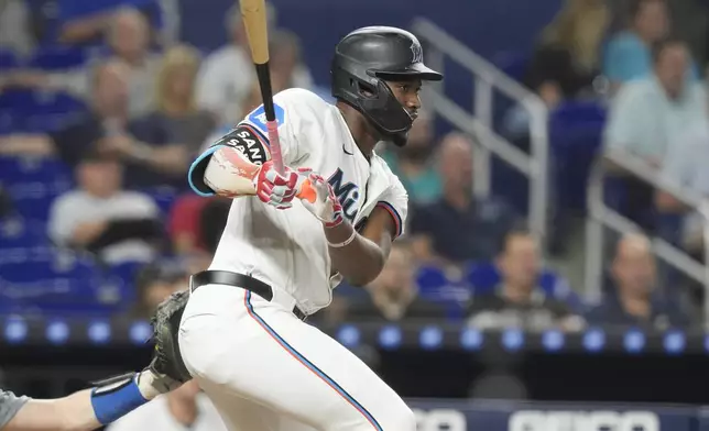 Miami Marlins' Jesús Sánchez (12) hits a single during the first inning of a baseball game against the Los Angeles Dodgers, Tuesday, Sept. 17, 2024, in Miami. (AP Photo/Marta Lavandier)