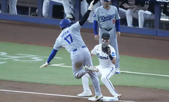 Los Angeles Dodgers' Shohei Ohtani (17) of Japan, steals third base, for his 50th stolen base of the season, as Miami Marlins third baseman Connor Norby was late with the tag during the first inning of a baseball game, Thursday, Sept. 19, 2024, in Miami. (AP Photo/Wilfredo Lee)