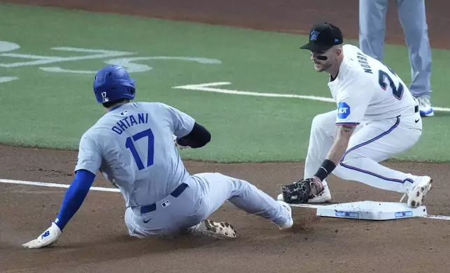 Los Angeles Dodgers' Shohei Ohtani (17) of Japan, steals third base, for his 50th stolen base of the season, as Miami Marlins third baseman Connor Norby attempts the tag during the first inning of a baseball game, Thursday, Sept. 19, 2024, in Miami. (AP Photo/Wilfredo Lee)