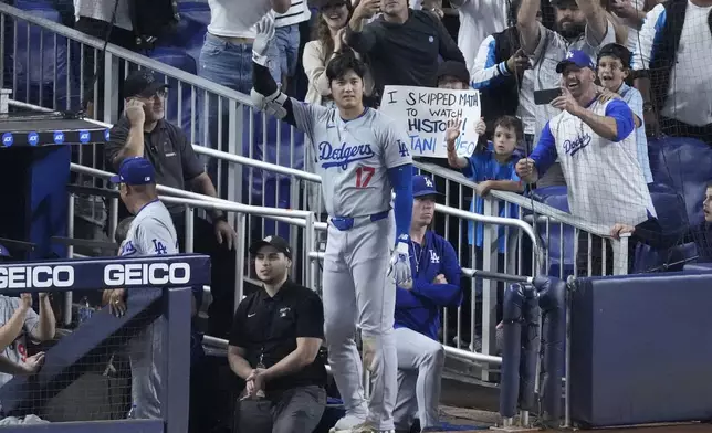 Los Angeles Dodgers' Shohei Ohtani (17) waves to fans after he hit a home run scoring Andy Pages, during the seventh inning of a baseball game against the Miami Marlins, Thursday, Sept. 19, 2024, in Miami. (AP Photo/Wilfredo Lee)