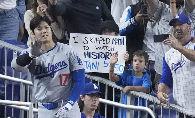 Los Angeles Dodgers' Shohei Ohtani (17) waves to fans after he hit a home run scoring Andy Pages, during the seventh inning of a baseball game against the Miami Marlins, Thursday, Sept. 19, 2024, in Miami. (AP Photo/Wilfredo Lee)