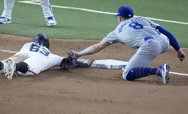 Los Angeles Dodgers third baseman Enrique Hernández (8) tags out Miami Marlins' Xavier Edwards (63) as he dives into third base during the seventh inning of a baseball game, Wednesday, Sept. 18, 2024, in Miami. (AP Photo/Wilfredo Lee)