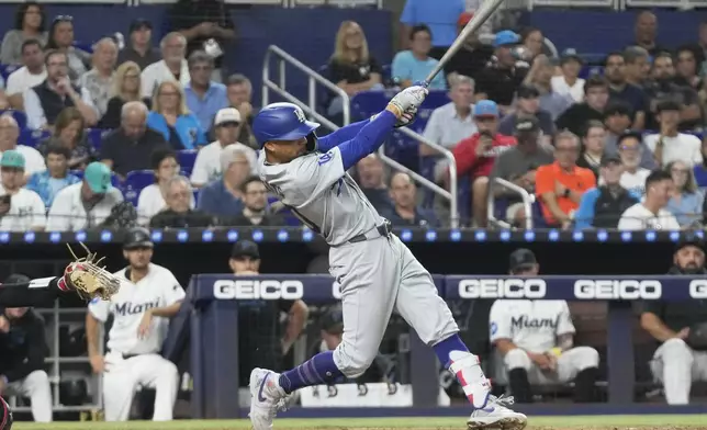 Los Angeles Dodgers' Mookie Betts (50) a triple to center field during the fifth inning of a baseball game against the Miami Marlins, Tuesday, Sept. 17, 2024, in Miami. (AP Photo/Marta Lavandier)