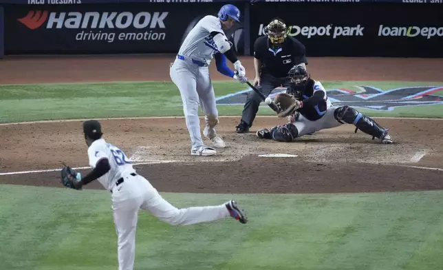 Los Angeles Dodgers' Shohei Ohtani hits a home run scoring Andy Pages off of Miami Marlins pitcher George Soriano (62) during the sixth inning of a baseball game, Thursday, Sept. 19, 2024, in Miami. (AP Photo/Wilfredo Lee)