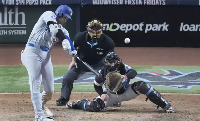 Los Angeles Dodgers' Shohei Ohtani (17) hits a home run scoring Andy Pages, during the seventh inning of a baseball game against the Miami Marlins, Thursday, Sept. 19, 2024, in Miami. (AP Photo/Wilfredo Lee)