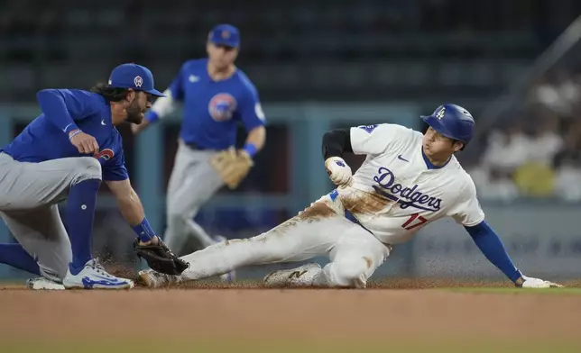 Los Angeles Dodgers designated hitter Shohei Ohtani (17) steals second base ahead of a throw to Chicago Cubs shortstop Dansby Swanson, left, during the second inning of a baseball game against the Chicago Cubs in Los Angeles, Wednesday, Sept. 11, 2024. (AP Photo/Ashley Landis)