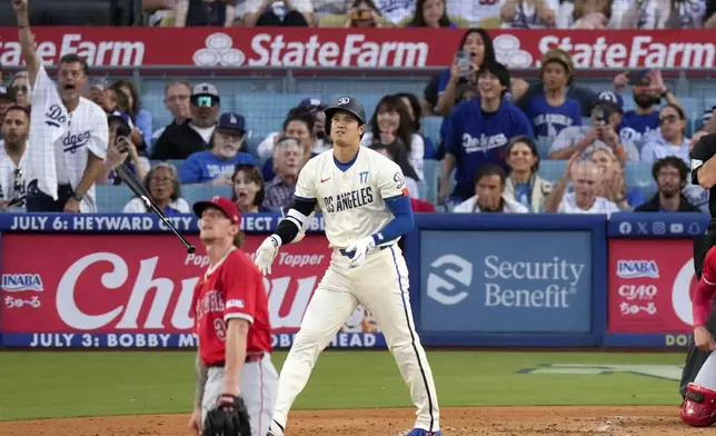 Los Angeles Dodgers' Shohei Ohtani, right, heads to first for a two-run home run as Los Angeles Angels starting pitcher Zach Plesac watches during the third inning of a baseball game Saturday, June 22, 2024, in Los Angeles. (AP Photo/Mark J. Terrill)