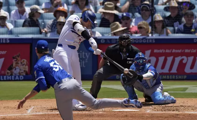 Los Angeles Dodgers' Shohei Ohtani, second from left, hits a solo home run as Kansas City Royals starting pitcher Brady Singer, left, and catcher Freddy Fermin, right, watch along with home plate umpire Ryan Additon during the third inning of a baseball game Sunday, June 16, 2024, in Los Angeles. (AP Photo/Mark J. Terrill)