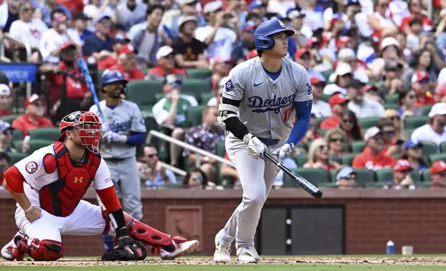 Los Angeles Dodgers designated hitter Shohei Ohtani, right, watches his home run against the St. Louis Cardinals during the fifth inning of a baseball game Sunday, Aug. 18, 2024, in St. Louis. (AP Photo/Jeff Le)