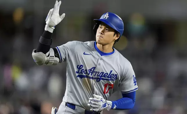 Los Angeles Dodgers designated hitter Shohei Ohtani celebrates as he runs the bases for his solo home run during the ninth inning of a baseball game against the Washington Nationals at Nationals Park, Tuesday, April 23, 2024, in Washington. The Dodgers won 4-1. (AP Photo/Alex Brandon)