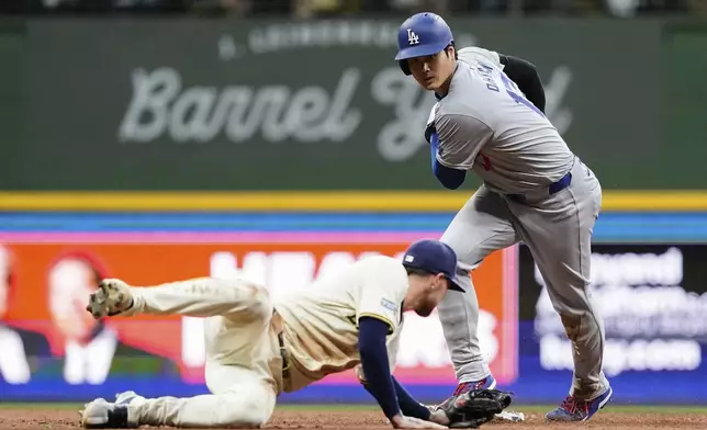 Los Angeles Dodgers' Shohei Ohtani, right, steals second base past Milwaukee Brewers' Brice Turang during the second inning of a baseball game Wednesday, Aug. 14, 2024, in Milwaukee. (AP Photo/Aaron Gash)