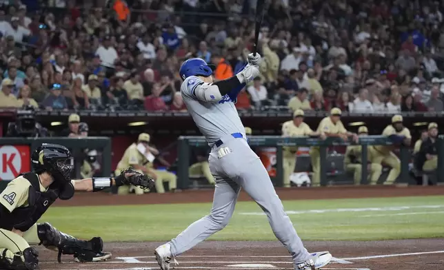 Los Angeles Dodgers designated hitter Shohei Ohtani, right, of Japan, connects for a home run as Arizona Diamondbacks catcher Adrian Del Castillo, left, looks on during the first inning of a baseball game Saturday, Aug. 31, 2024, in Phoenix. (AP Photo/Ross D. Franklin)