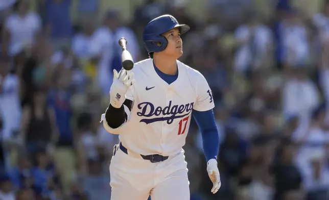 Los Angeles Dodgers designated hitter Shohei Ohtani tosses his bat after hitting a solo home run during the fifth inning of a baseball game against the Boston Red Sox, Sunday, July 21, 2024, in Los Angeles. (AP Photo/Ryan Sun)