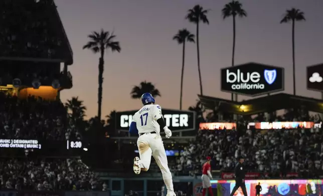 Los Angeles Dodgers designated hitter Shohei Ohtani (17) runs the bases after hitting a home run during the fifth inning of a baseball game against the Los Angeles Angels in Los Angeles, Friday, June 21, 2024. Austin Barnes also scored. (AP Photo/Ashley Landis)