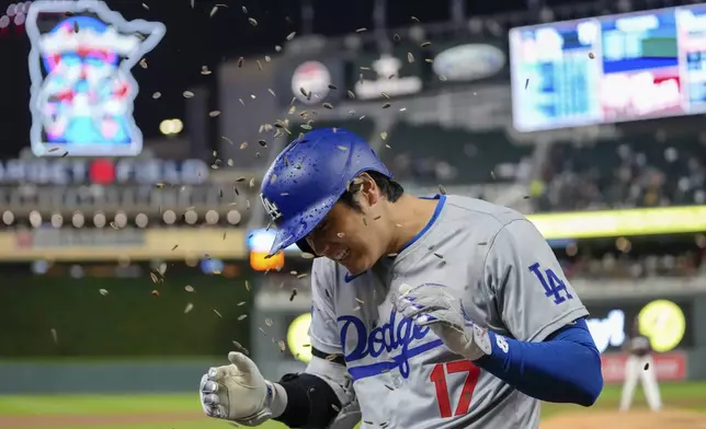 Los Angeles Dodgers designated hitter Shohei Ohtani is sprinkled with sunflower seeds after hitting a solo home run during the seventh inning of a baseball game against the Minnesota Twins, Monday, April 8, 2024, in Minneapolis. (AP Photo/Abbie Parr)