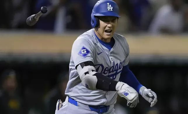 Los Angeles Dodgers' Shohei Ohtani tosses his bat after hitting a three-run home run against the Oakland Athletics during the ninth inning of a baseball game Friday, Aug. 2, 2024, in Oakland, Calif. (AP Photo/Godofredo A. Vásquez)