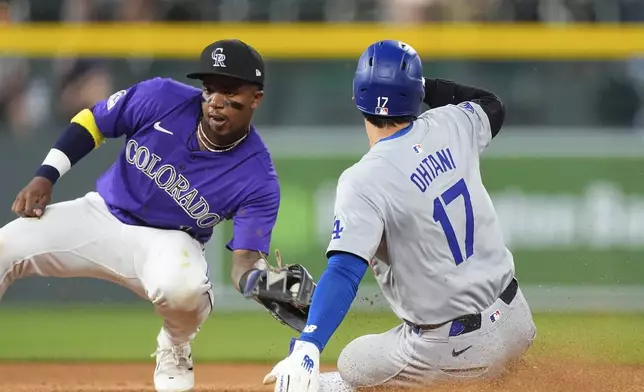 Los Angeles Dodgers' Shohei Ohtani, right, slides safely into second base for a steal as Colorado Rockies second baseman Adael Amador, left, fields the throw in the eighth inning of a baseball game Monday, June 17, 2024, in Denver. (AP Photo/David Zalubowski)