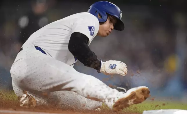 Los Angeles Dodgers' Shohei Ohtani steals third base during the fourth inning of a baseball game against the Arizona Diamondbacks, Tuesday, May 21, 2024, in Los Angeles. (AP Photo/Marcio Jose Sanchez)