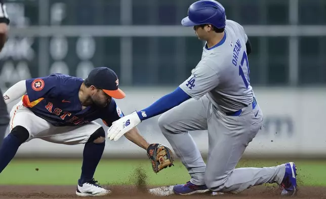 Houston Astros second baseman Jose Altuve, left, misses a tag as Los Angeles Dodgers designated hitter Shohei Ohtani (17) steals second during the ninth inning of a baseball game Sunday, July 28, 2024, in Houston. (AP Photo/Kevin M. Cox)