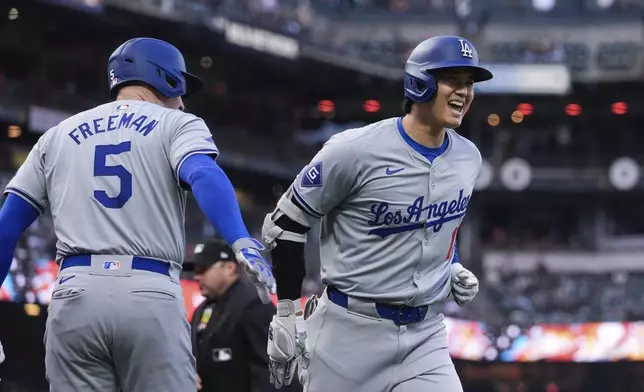 Los Angeles Dodgers' Shohei Ohtani, right, is congratulated by Freddie Freeman after his solo home run against the San Francisco Giants during the fourth inning of a baseball game Tuesday, May 14, 2024, in San Francisco. (AP Photo/Godofredo A. Vásquez)