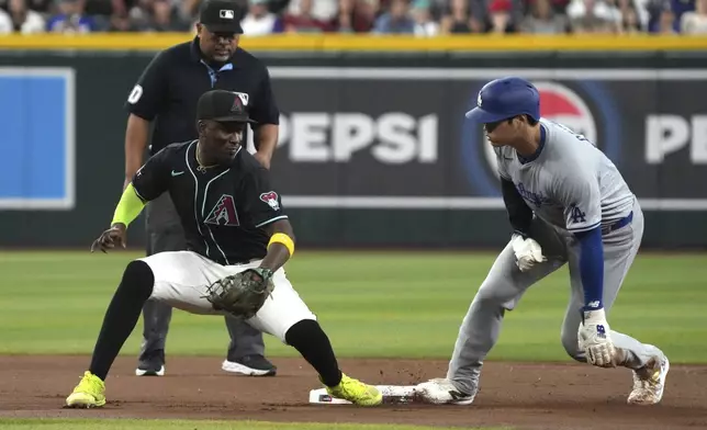 Los Angeles Dodgers' Shohei Ohtani, right, steals second base in front of Arizona Diamondbacks shortstop Geraldo Perdomo, front left, in the seventh inning during a baseball game, Monday, Sept. 2, 2024, in Phoenix. (AP Photo/Rick Scuteri)