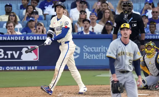 Los Angeles Dodgers' Shohei Ohtani, left, heads to first for a solo home run as Milwaukee Brewers relief pitcher Bryan Hudson, second from left, and catcher William Contreras, right, watch along with home plate umpire Edwin Moscoso during the eighth inning of a baseball game Saturday, July 6, 2024, in Los Angeles. (AP Photo/Mark J. Terrill)