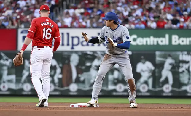 Los Angeles Dodgers' Shohei Ohtani, right, gestures after stealing second during the first inning of a baseball game against the St. Louis Cardinals Saturday, Aug. 17, 2024, in St. Louis. (AP Photo/Jeff Le)