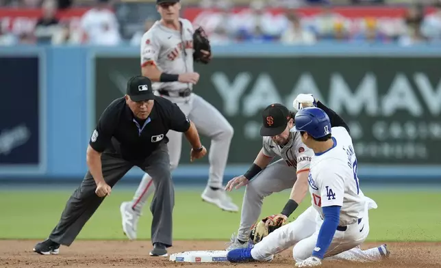 San Francisco Giants second baseman Brett Wisely, second from right, tags out Los Angeles Dodgers' Shohei Ohtani, right, on a steal-attempt during the first inning of a baseball game Monday, July 22, 2024, in Los Angeles. (AP Photo/Marcio Jose Sanchez)