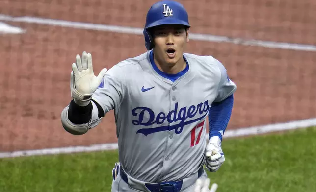 Los Angeles Dodgers' Shohei Ohtani returns to the dugout after hitting a two-run home run off Pittsburgh Pirates starting pitcher Paul Skenes during the third inning of a baseball game in Pittsburgh, Wednesday, June 5, 2024. (AP Photo/Gene J. Puskar)