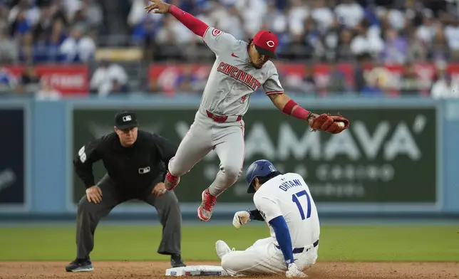 Los Angeles Dodgers designated hitter Shohei Ohtani (17) steals second base ahead of a throw to Cincinnati Reds second baseman Santiago Espinal (4) during the first inning of a baseball game in Los Angeles, Thursday, May 16, 2024. (AP Photo/Ashley Landis)