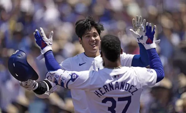 Los Angeles Dodgers' Shohei Ohtani, left, is congratulated by Teoscar Hernández after hitting a solo home run during the sixth inning of a baseball game against the Kansas City Royals Sunday, June 16, 2024, in Los Angeles. (AP Photo/Mark J. Terrill)