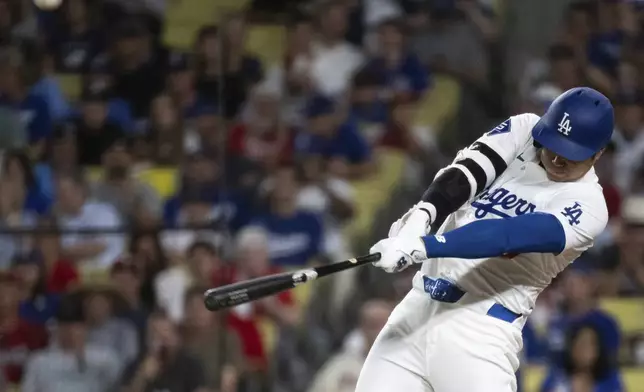 Los Angeles Dodgers' Shohei Ohtani hits a solo home run during the eighth inning of a baseball game against the Philadelphia Phillies in Los Angeles, Monday, Aug. 5, 2024. (AP Photo/Kyusung Gong)