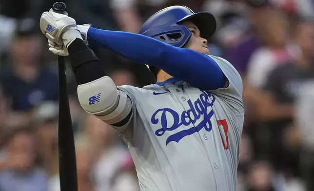 Los Angeles Dodgers' Shohei Ohtani watches his solo home run off Colorado Rockies starting pitcher Austin Gomber during the sixth inning of a baseball game Tuesday, June 18, 2024, in Denver. (AP Photo/David Zalubowski)