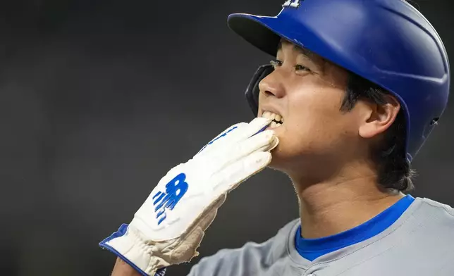 Los Angeles Dodgers' Shohei Ohtani pulls his glove off as he walks to the dugout during the eighth inning of the team's baseball game against the Washington Nationals at Nationals Park, Wednesday, April 24, 2024, in Washington. (AP Photo/Alex Brandon)