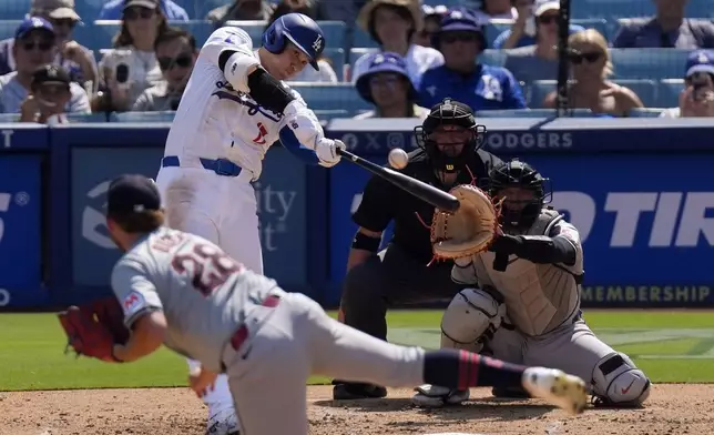 Los Angeles Dodgers' Shohei Ohtani, second from left, hits a solo home run as Cleveland Guardians starting pitcher Tanner Bibee, left, watches along with catcher Bo Naylor, right, and home plate umpire Dan Bellino during the fifth inning of a baseball game, Sunday, Sept. 8, 2024, in Los Angeles. (AP Photo/Mark J. Terrill)