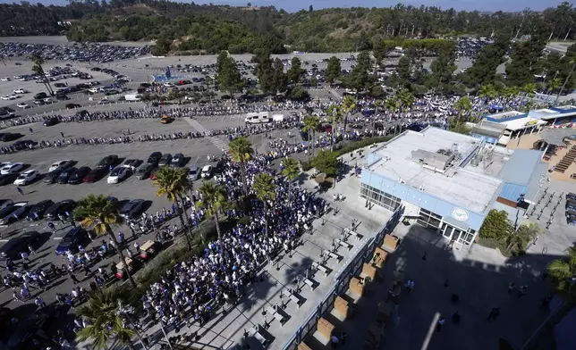 Fans line up to enter and get a bobblehead of Los Angeles Dodgers' Shohei Ohtani prior to a baseball game between the Dodgers and the Baltimore Orioles, Wednesday, Aug. 28, 2024, in Los Angeles. (AP Photo/Mark J. Terrill)